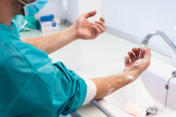 Doctor washing his hands before operating inside private clinic - Medical worker inside hospital - Health care and hygiene concept - Focus on right hand